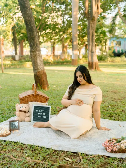 A peaceful moment during her outdoor picnic shoot, surrounded by nature and props that tell the story of her excitement.