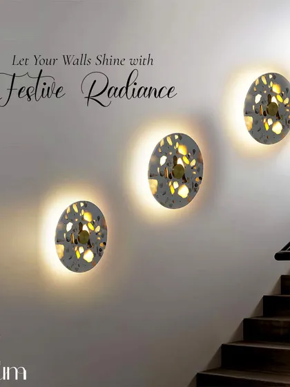 A trio of patterned, backlit wall sconces arranged along a staircase. This installation adds festive magic and a beautiful design element to a transitional space.