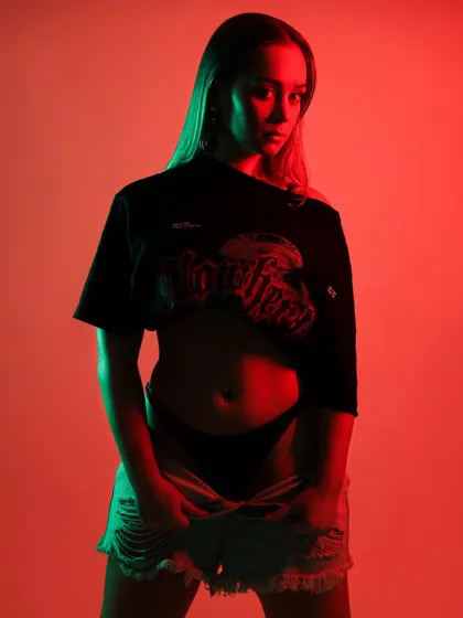 A full-body shot of the dancer, showing how the contrasting red and green lights play across her entire form. The pose is full of energy and captures the essence of movement.