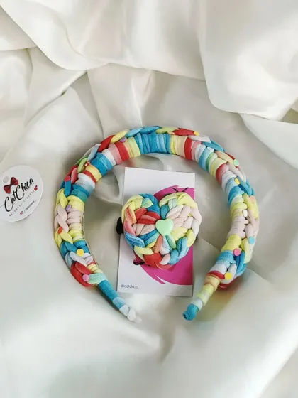 A vibrant rainbow braided headband and matching heart hair tie set.