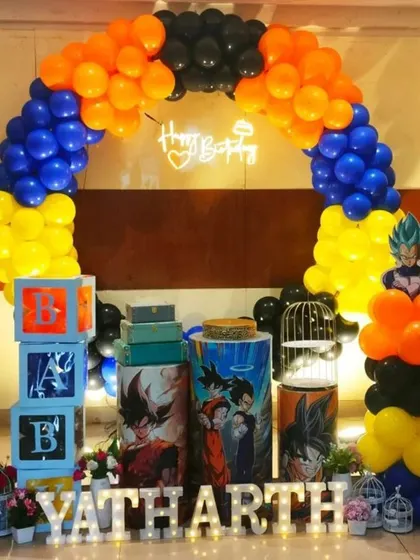Another look at the action-packed Goku and Vegeta theme. The balloon arch in blue, orange, and yellow frames the setup, which includes themed plinths and character cutouts.