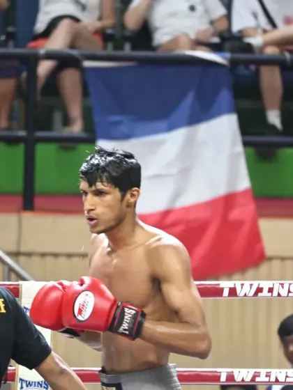 Our fighter standing ready in the ring, with the Indian flag visible in the background. We fight with the pride of our nation on our shoulders.