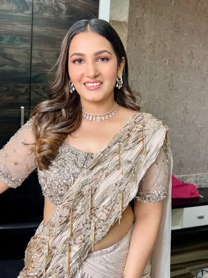 A happy and confident shot of the final look. The makeup is subtle yet glamorous, enhancing her natural beauty for the special occasion.
