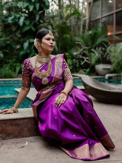 A beautiful bride in her colorful lehenga, sitting by the pool. We use the venue's features to create unique and stylish portraits.