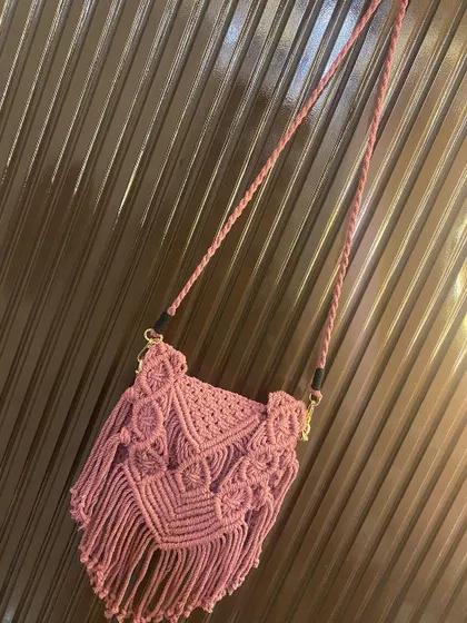 A full view of the dusty pink macrame sling bag, showing the braided strap and the detailed V-shaped flap design. All my bags are made with washable cotton cord.