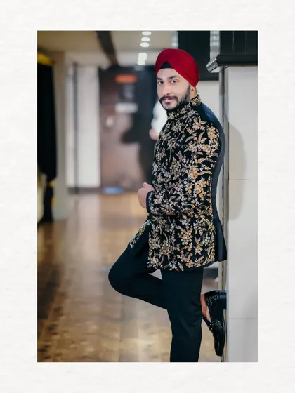 A dapper portrait of the groom in his black and gold embroidered sherwani. This shot captures his stylish and confident look for the engagement ceremony.