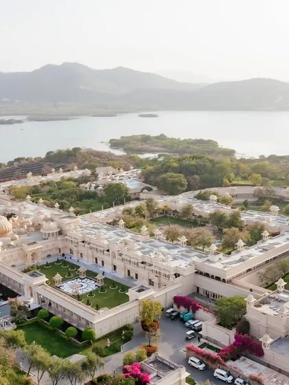 An aerial drone shot of The Leela Palace Udaipur, showcasing its stunning location on the banks of Lake Pichola. We help you select destination venues that offer not just a location, but a breathtaking experience.