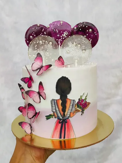 A beautiful cake for a teenager, featuring an illustration of a girl with a bouquet. The design is enhanced with pink butterflies and isomalt lollipops.