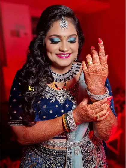 A playful pose from Akshatha at her reception, showing off her beautiful henna and the stunning details of her jewelry and makeup.