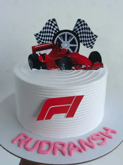 For the racing enthusiast, a custom F1 themed cake. This design features the iconic F1 logo, a race car, and checkered flags, making it the perfect centerpiece for a fan's birthday party.