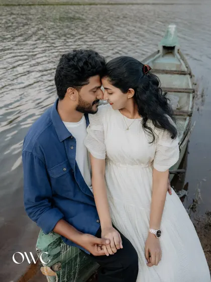 An intimate portrait of a couple sitting on a boat, their foreheads touching in a moment of deep connection.