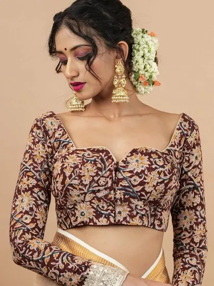 A perfect example of how jewellery can be the centerpiece of an outfit. Here, the model showcases a pair of oversized, handcrafted jhumkas with a beautiful floral design and full-bodied structure. Paired with a Kalamkari print blouse, this look balances traditional motifs with contemporary style.