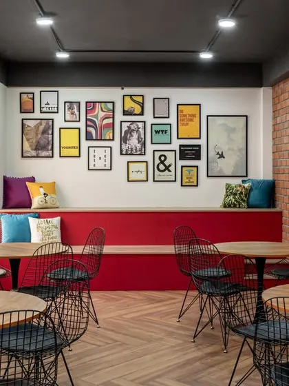 The office cafeteria and pantry doubles as a space for events. With its eclectic gallery wall, built-in seating, and industrial-style chairs, it’s a versatile hub for team gatherings.