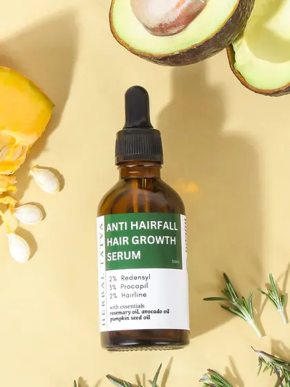 This top down shot for an anti hairfall serum showcases its natural ingredients like pumpkin, avocado, and rosemary. The yellow background makes the composition pop, creating a bright and healthy vibe.