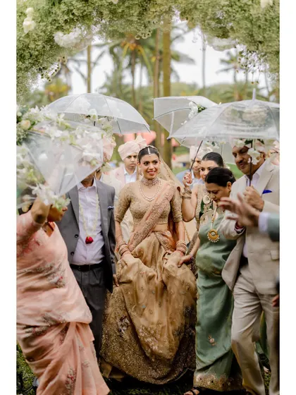 Even a little rain can't stop the celebration. The bride's entrance under umbrellas adds a unique and charming element to her wedding story.