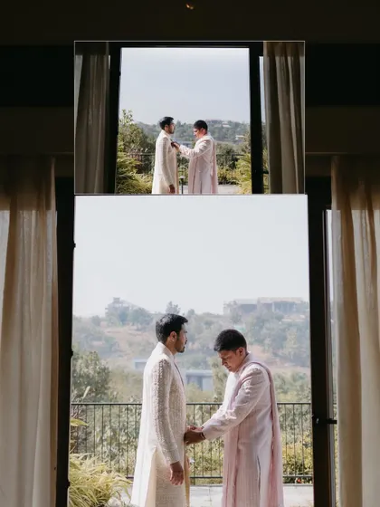 An artistic shot of the groom getting ready, with his reflection in a window overlooking a scenic landscape, creating a multi-layered image.