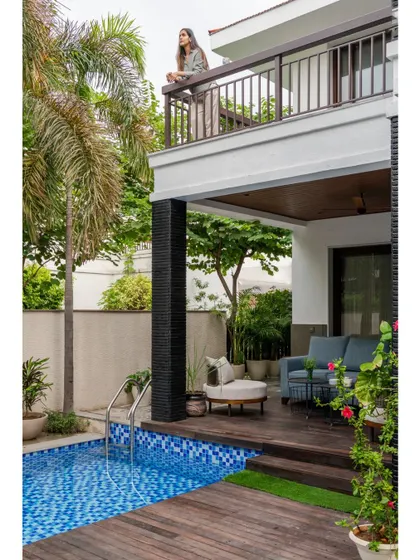 The transformed exterior of "Villa Tranquility," featuring a new poolside deck, a comfortable outdoor lounge area, and a balcony. This project showcases our expertise in creating luxurious outdoor living spaces.