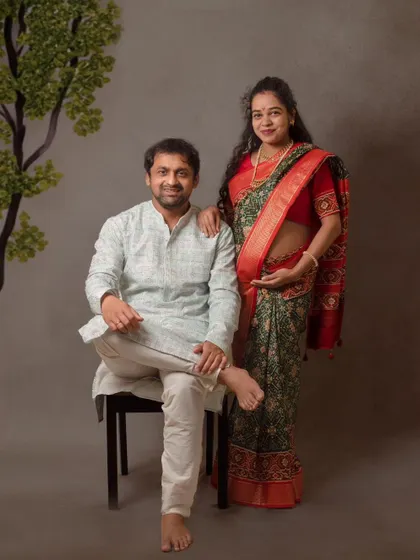 A formal portrait of a couple in traditional attire. This style of maternity photography creates a timeless and dignified family heirloom.