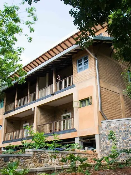 The multi-story residential block at PLENTI House, built with adobe bricks and featuring long verandas for circulation and relaxation.