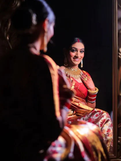 A beautiful shot of the bride's reflection in a mirror as she gets ready. This creative angle captures a moment of quiet contemplation and happiness.