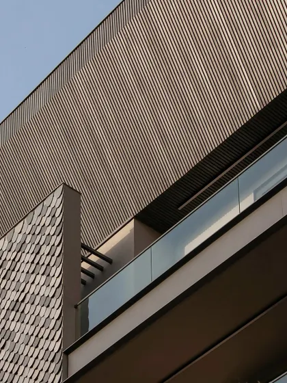 A detail shot from our Gurugram builder floor, showing the texture of the shingles against the clean lines of the aluminum louvers. This contrast creates a visually interesting and modern facade.