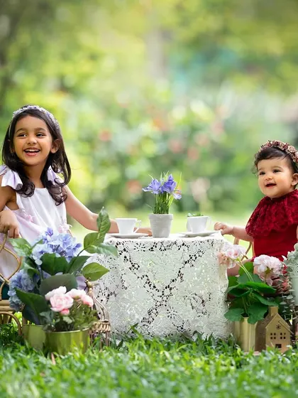A fun tea party for two sisters! Using props like this little table set can make a kids' photoshoot even more magical and bring out their playful side.