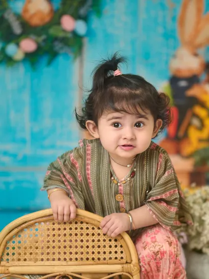 A beautiful close-up from an indoor session. The soft lighting and colorful backdrop highlight her adorable features and curious expression.