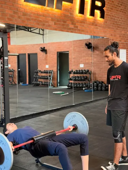 The coach-to-member ratio is key. Here you can see our coaches providing on-the-floor assistance, correcting form during weighted sit-ups and hip thrusts, and ensuring every member gets the attention they need.