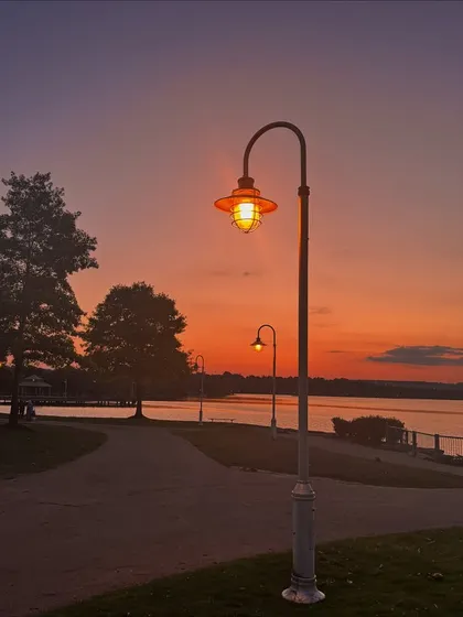 A beautiful sunset over the water in an Ontario park, with streetlights just starting to glow.