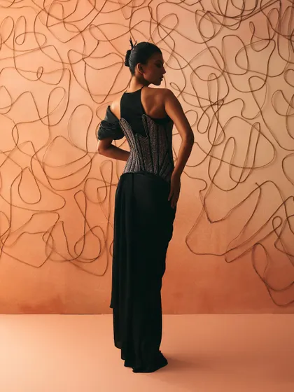 The back of the Nexus gown, where cords trace themselves into memory, tightening across an asymmetric corset over a pre-stitched sari.