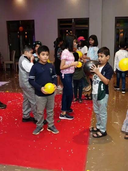 Kids getting ready for the next round of a balloon-popping game. The anticipation is part of the fun!