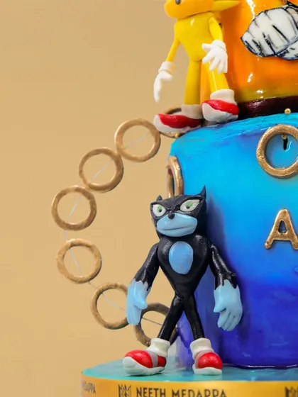 A close-up of the action-packed Sonic the Hedgehog cake, showing the detailed character figures and golden rings.