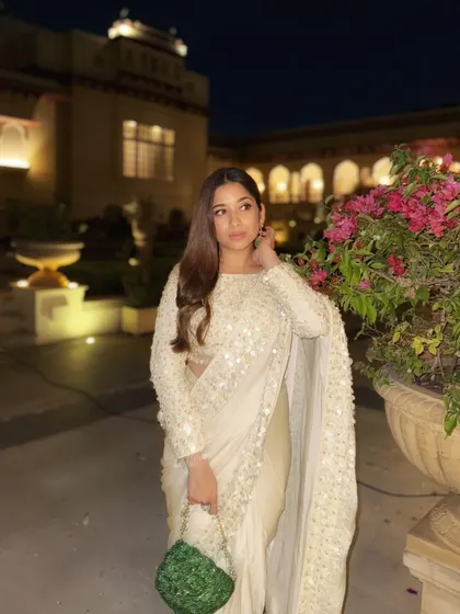 Another look at this stunning white saree. The right accessories, like these statement emerald earrings, can completely transform an outfit and tie the whole look together.