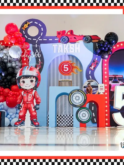 The main stage of the race car party, featuring a large driver cutout, a light-up number "5", and a dynamic track design.