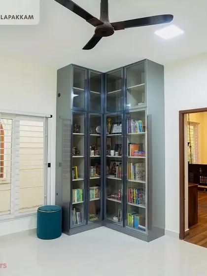 A floor-to-ceiling bookshelf in the Sithalapakkam villa, designed to house a large book collection, featuring grey frames and glass doors.