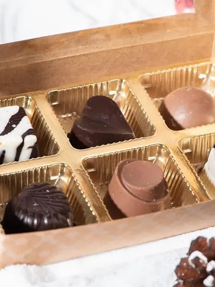 A box of six assorted soft-centered chocolates, perfect for Christmas gifting. The box includes a variety of milk, dark, and white chocolates with different fillings.
