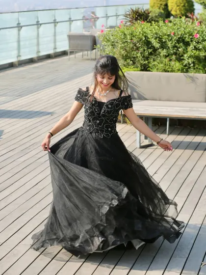 A joyful twirl on a sunny day. This off-shoulder black ball gown is both elegant and fun, perfect for a pre-wedding shoot with a touch of sophistication.