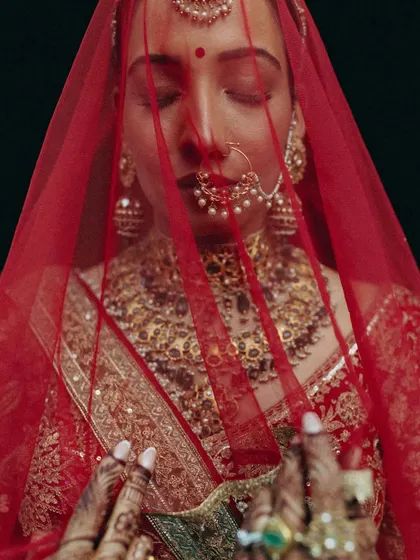 A quiet moment of reflection for the bride. The delicate veil, the intricate jewelry, and the soft light all come together to create a portrait that is both powerful and serene.