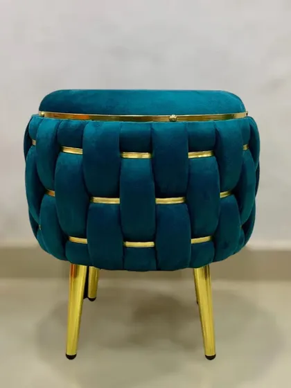 This elegant puffy stool is shown in a deep teal velvet, adding a pop of color and luxury.