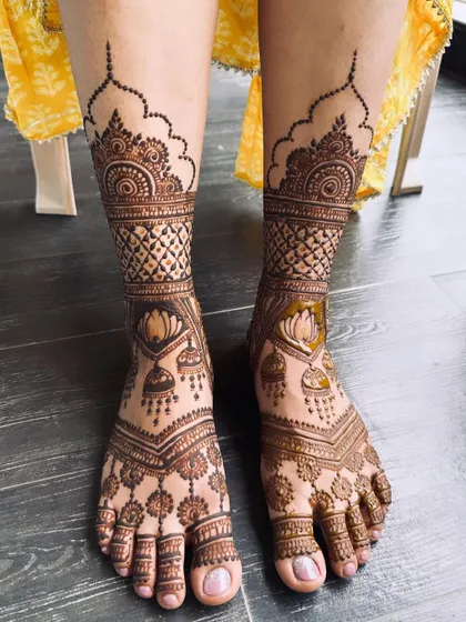 This design features lotus and jhumka motifs on the feet, with a simple, elegant border around the ankles.