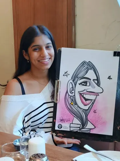 A happy guest with her caricature. My style is all about exaggerating features in a fun way to bring out the person's character.