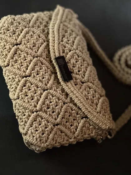 This beige clutch has such an intricate, beautiful pattern. It's a testament to the art of macrame.
