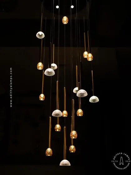 This cluster pendant features a mix of gold-toned rods with textured glass shades, some resembling pineapples and others simple domes. The combination creates a visually interesting and warm installation for any corner that needs a lift.