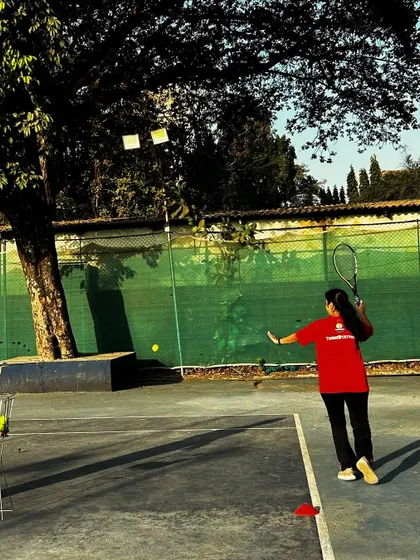 A player in our red team jersey practices her forehand during a drill, showing power and precision.