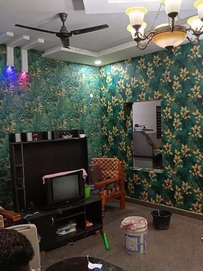 A living room fully wrapped in a green and gold leaf-patterned wallpaper. This creates a rich, luxurious feel, and I ensure the pattern matches perfectly at every corner.