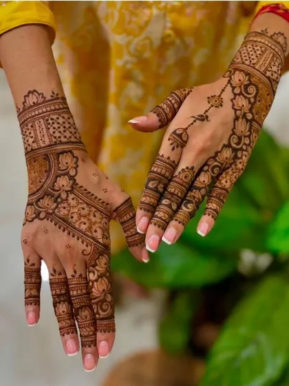 An elegant design for the back of the hands, featuring delicate floral vines and a hanging charm (jhumki) motif. This is a popular choice for engagements and parties.