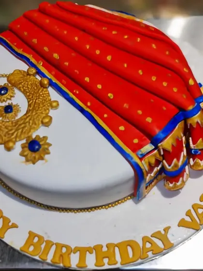A beautiful and traditional Maharashtrian saree cake. The detailed fondant work replicates the drape of a classic Paithani saree and is paired with edible golden jewelry.