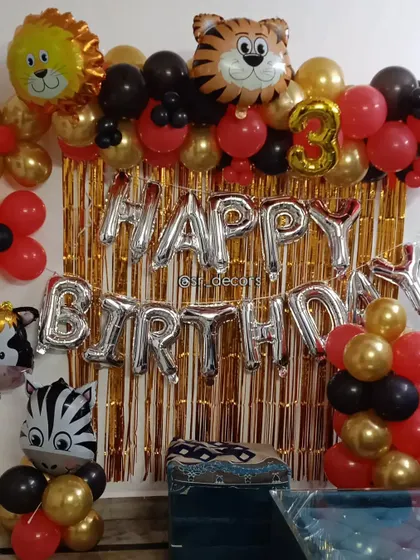 A simple yet fun jungle animal theme wall decor, perfect for smaller spaces. This setup includes a foil curtain, 'Happy Birthday' letters, and cute animal-shaped balloons.