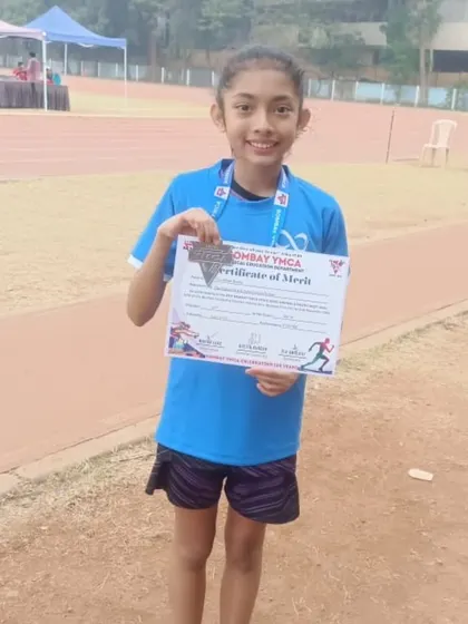 This young champion proudly displays her certificate of merit after a strong race.