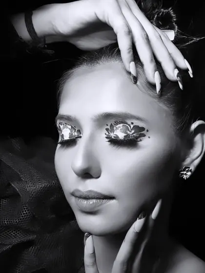 A creative makeup look designed specifically for black and white photography. The intricate, textured pattern on the eyelids creates a high-contrast, visually arresting effect without relying on color.